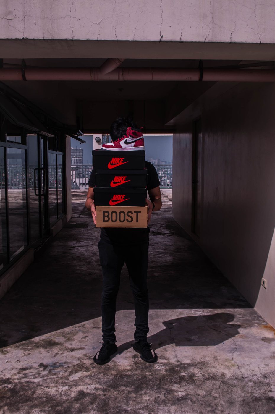 A person carries a stack of sneaker boxes