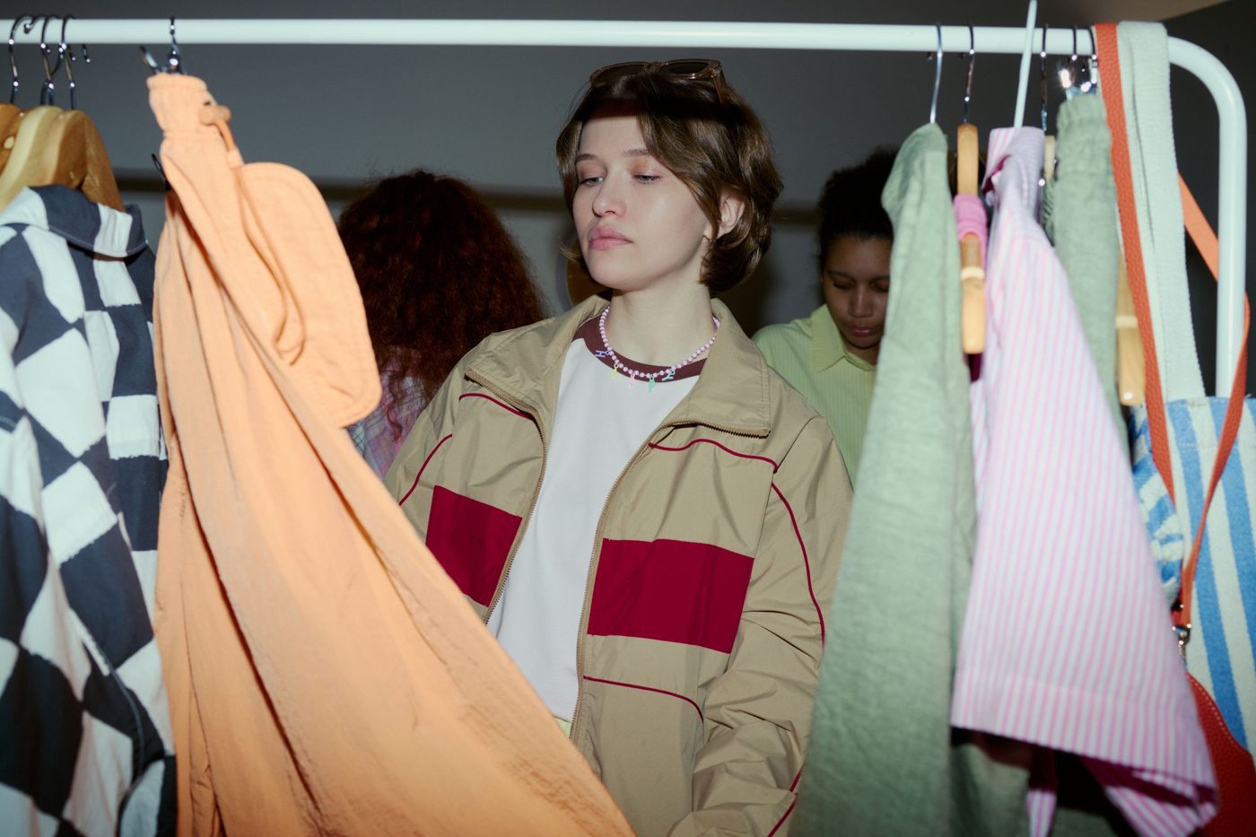 A shopper looks through a rail of colourful jackets