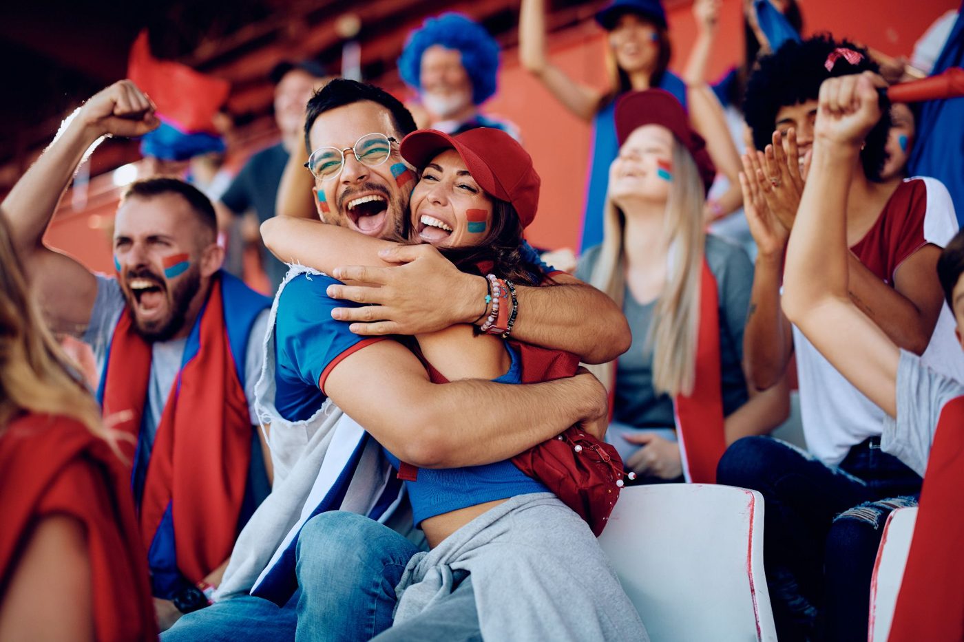 Football fans hugging and cheering in the stands