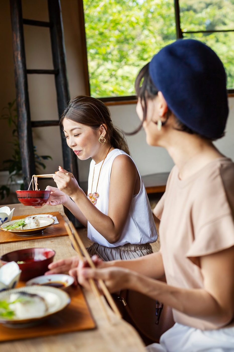 Two friends sharing lunch at a Japanese noodle bar