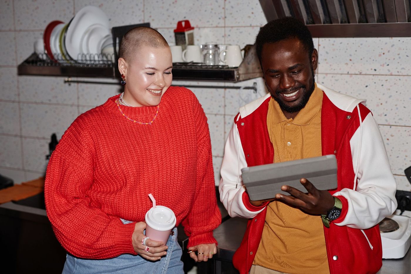 Two venue staff smiling at a tablet in the kitchen