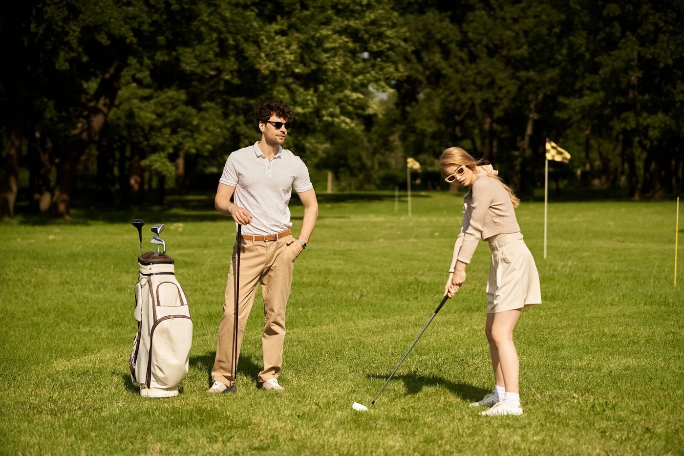 A couple play golf on a sunny fairway