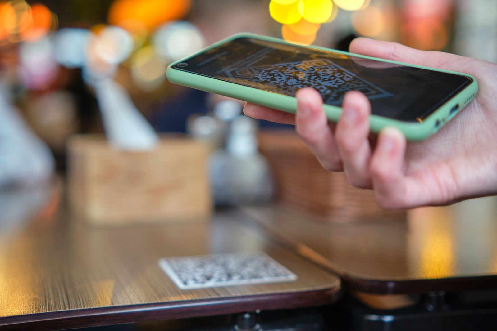 A customer scanning a QR code on a table with their phone